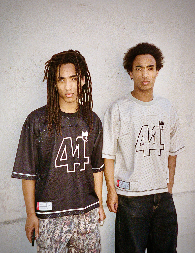 Deux hommes métis en Jersey 44 black et white posés contre un mur clair (argentique)