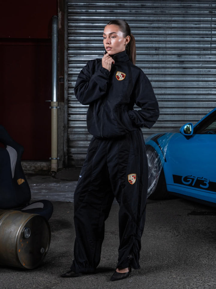 Model wearing the 911 tracksuit in black, zip jacket and jogger - Finesse lookbook