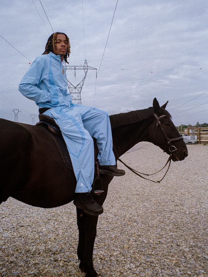 Model wearing the 911 tracksuit in blue, zip jacket and jogger - Finesse lookbook