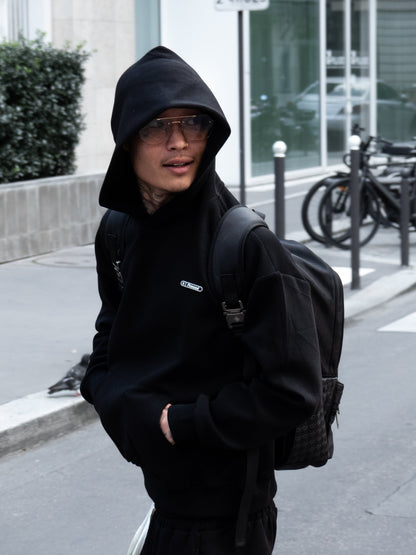 Mannequin en hoodie noir Finesse Air Cotton, capuche relevée, riant.