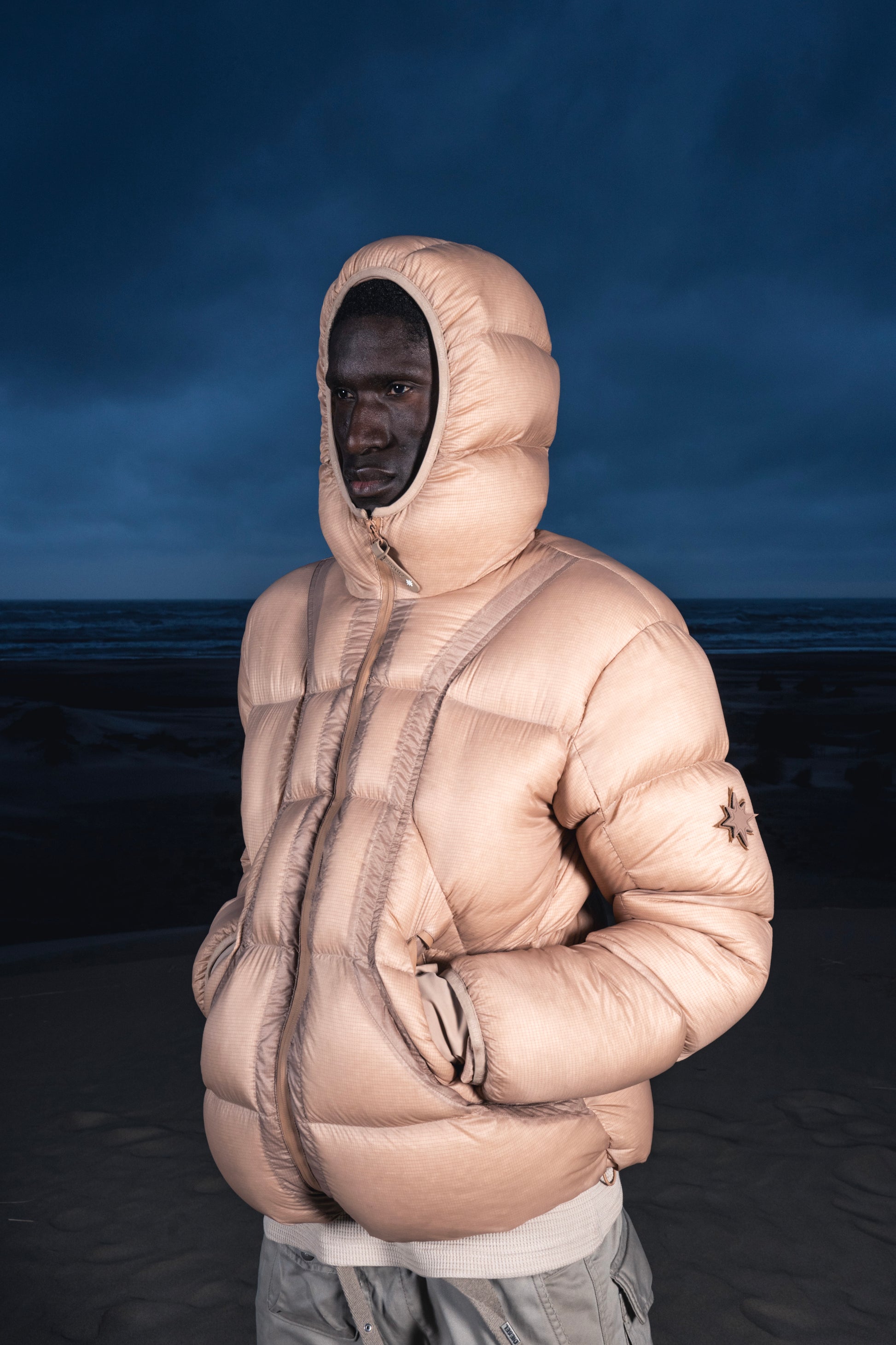 Zoom sur homme mains dans les poches portant la Alive Puffer Jacket beige.
