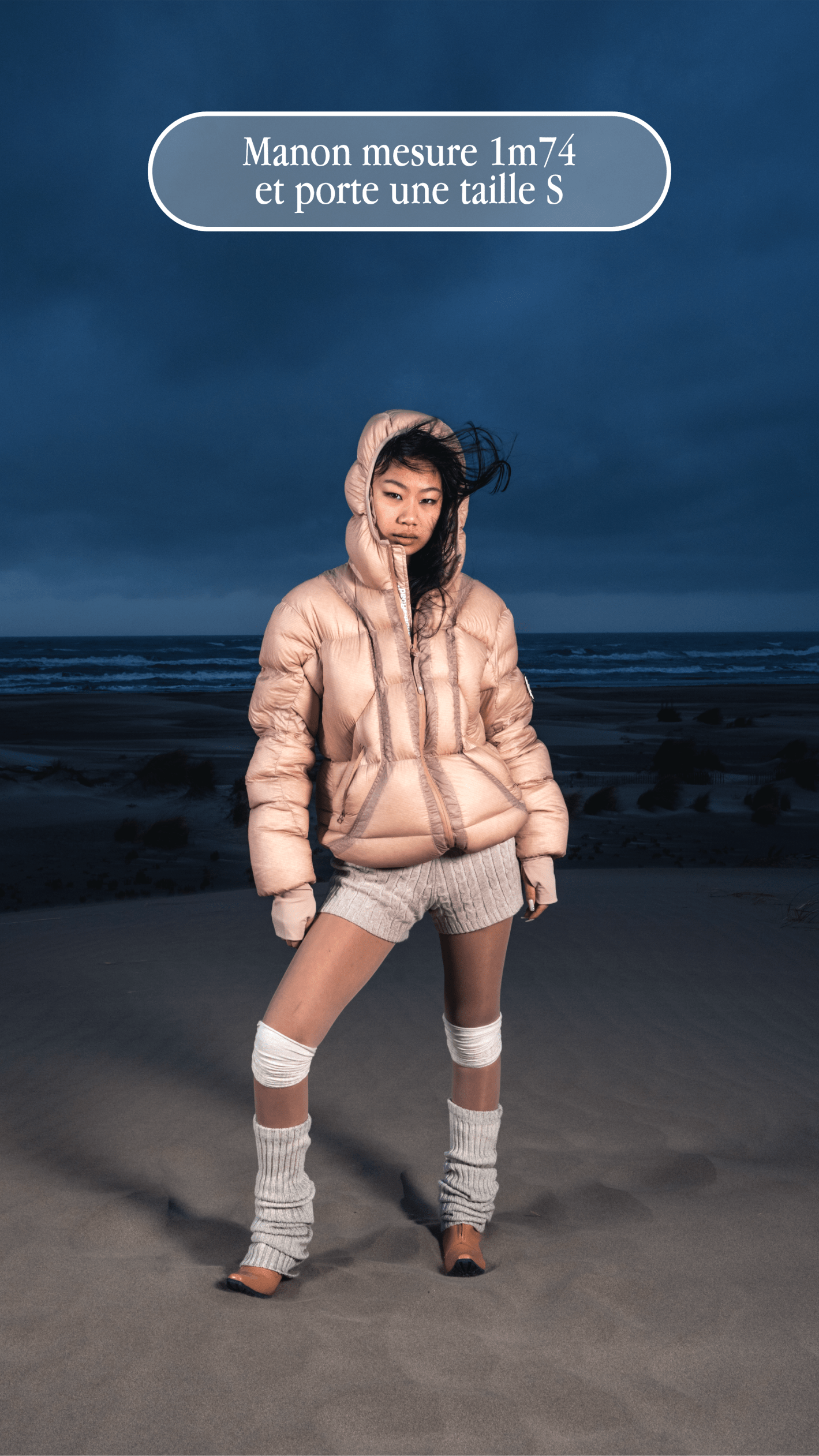 Femme dans dunes portant Alive Puffer Jacket noire, photo de guide de taille.