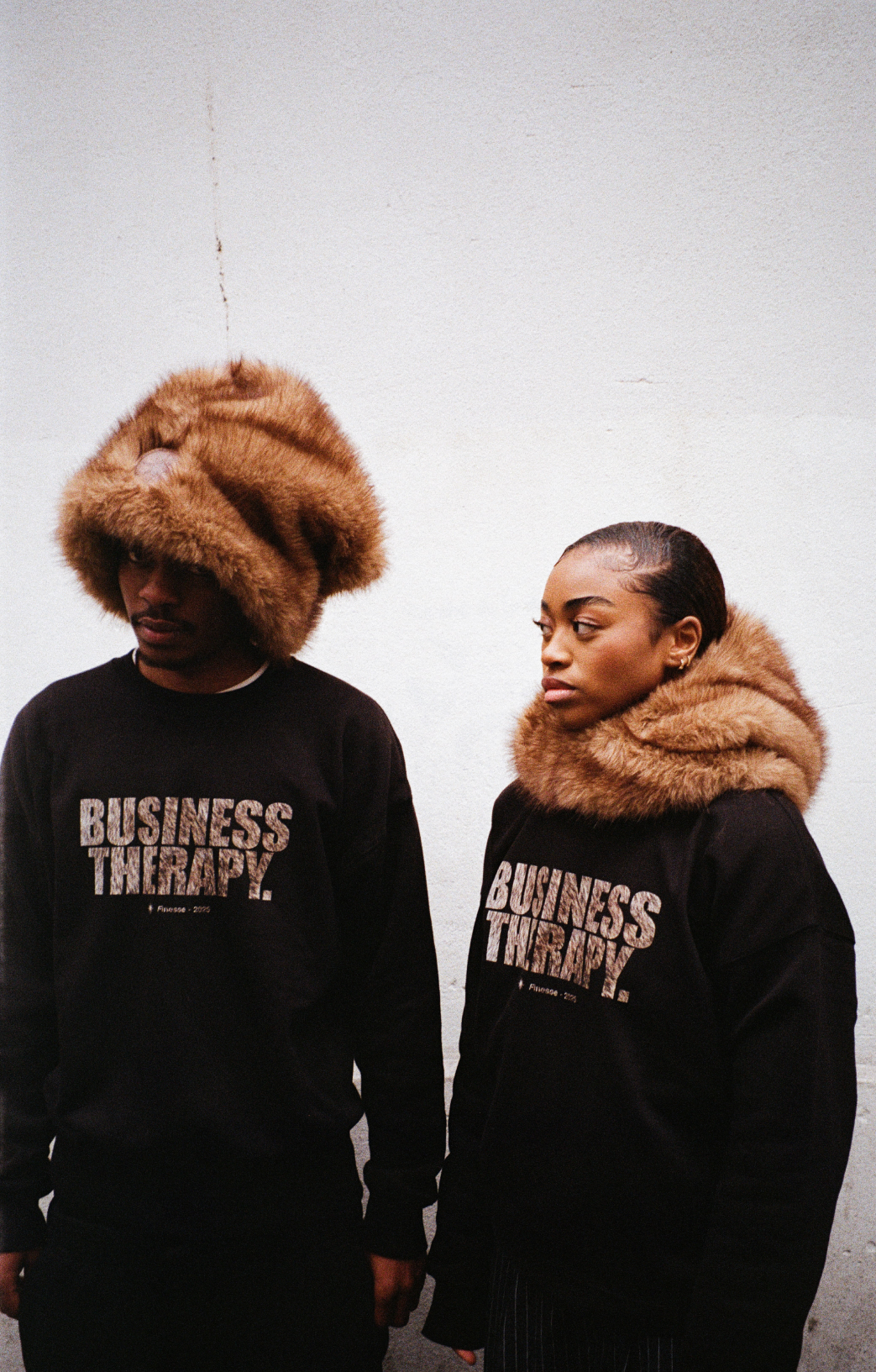 Deux mannequins portant Crew Neck Business Therapy FUR et FUR HOOD en extérieur urbain