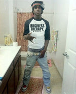 Rappeur faisant un signe de gang dans une salle de bain, portant le Face Multi Business Therapy black & white.