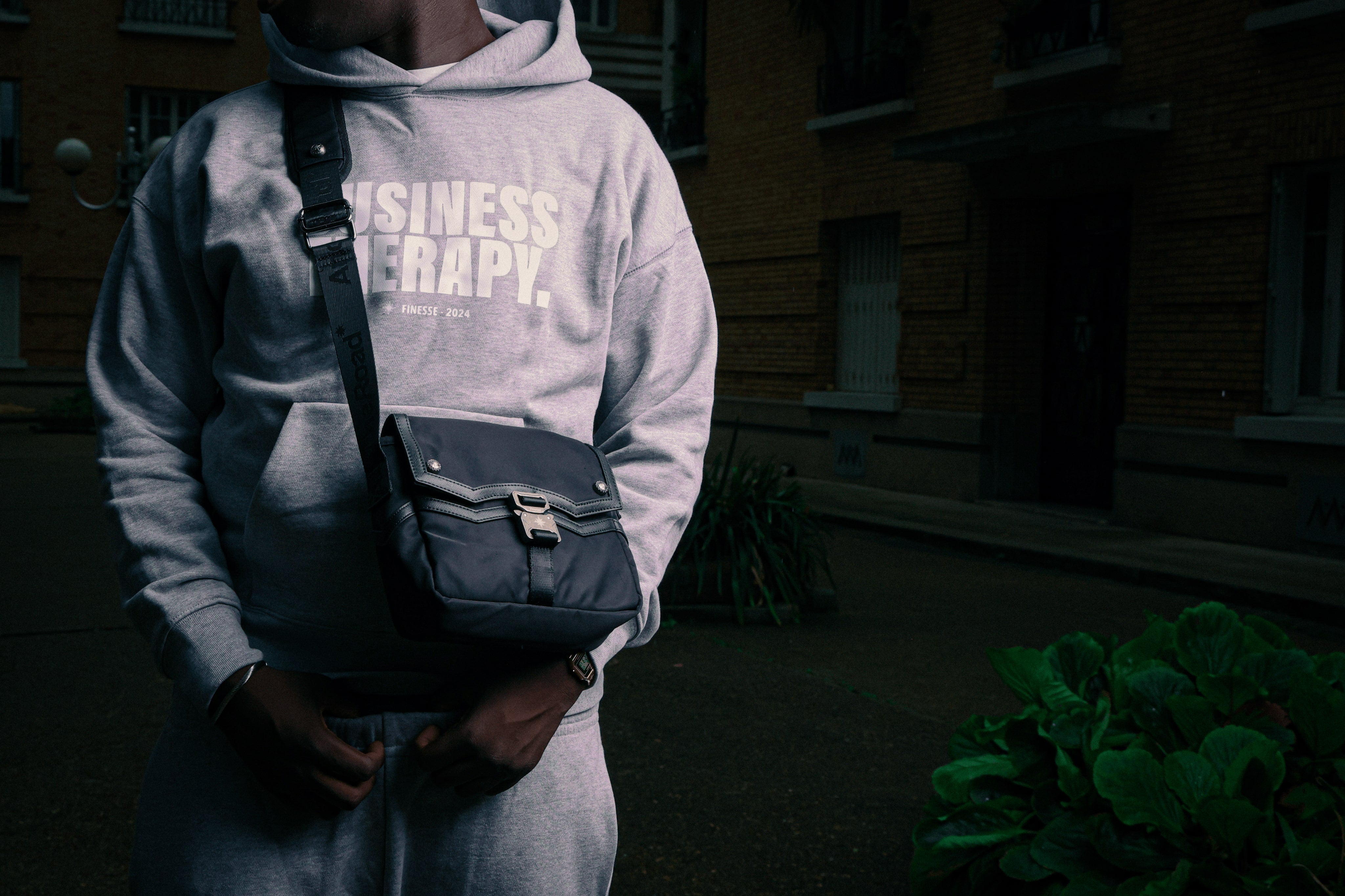 Homme en hoodie Business Therapy gris avec sacoche Memorial Bag en bandoulière