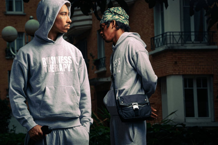 Deux hommes en jogging Business Therapy gris, l’un tatoué, l’autre avec la Memorial Bag.