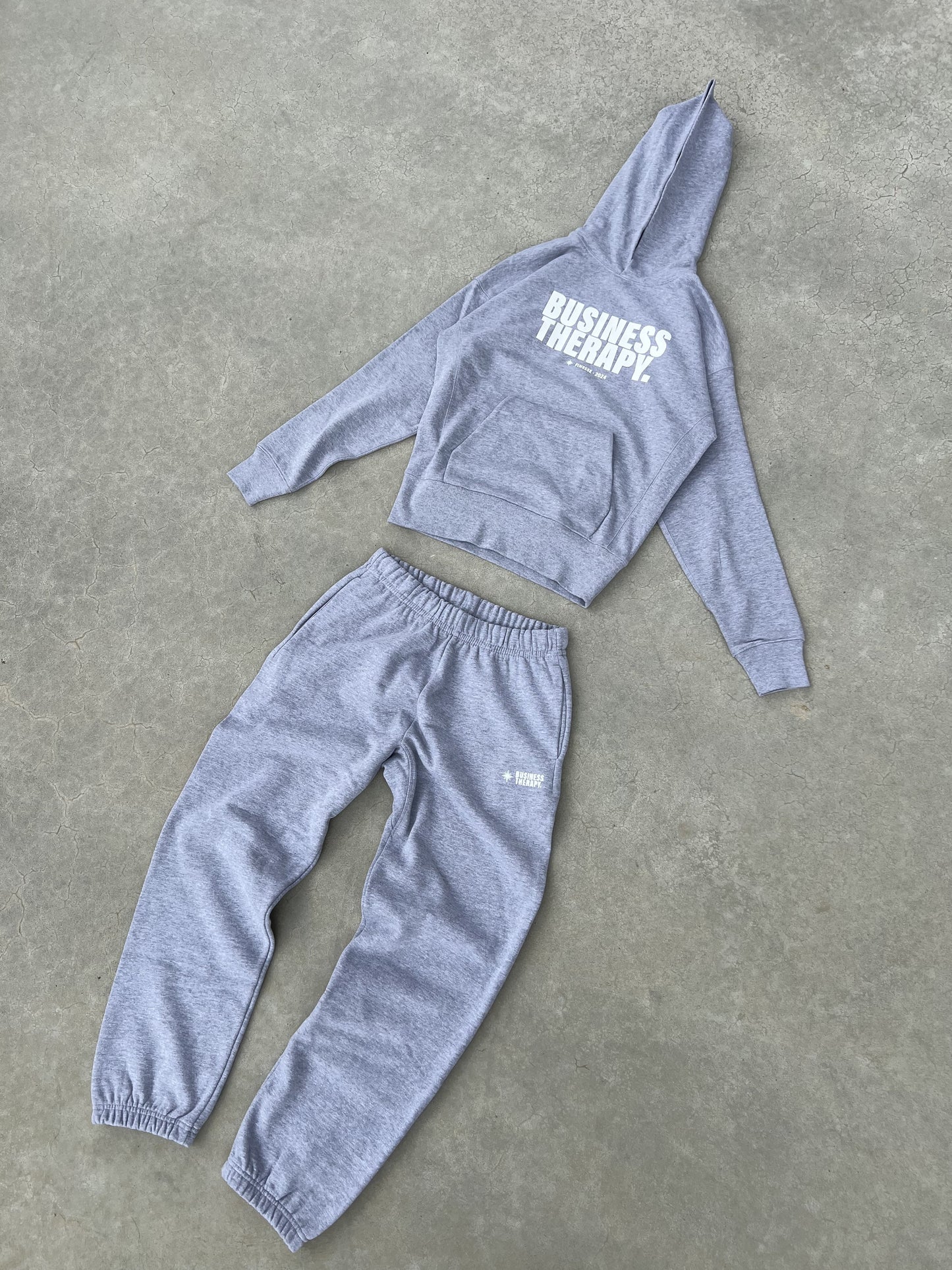 Ensemble jogging gris Business Therapy présenté en packshot.