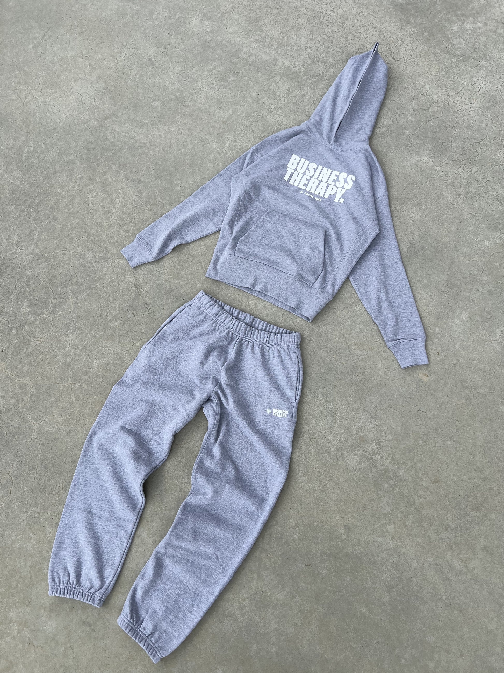 Ensemble jogging gris Business Therapy présenté en packshot.