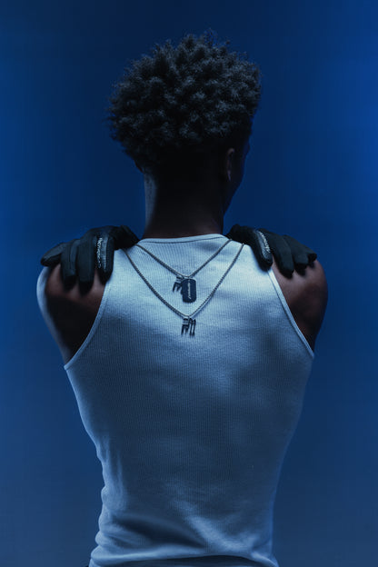 Photo de dos d’un homme en débardeur blanc portant des gants Finesse et deux chaînes Finesse mises en évidence.