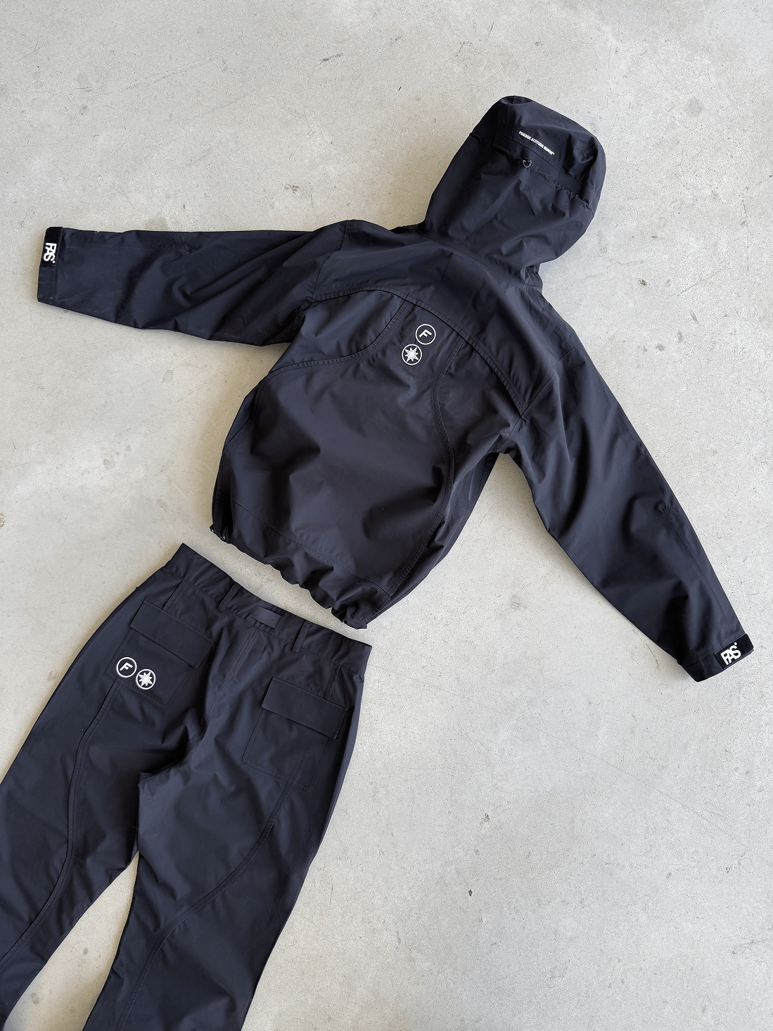 FAS Hardshell et Hardpant noirs posés au sol, pantalon retourné