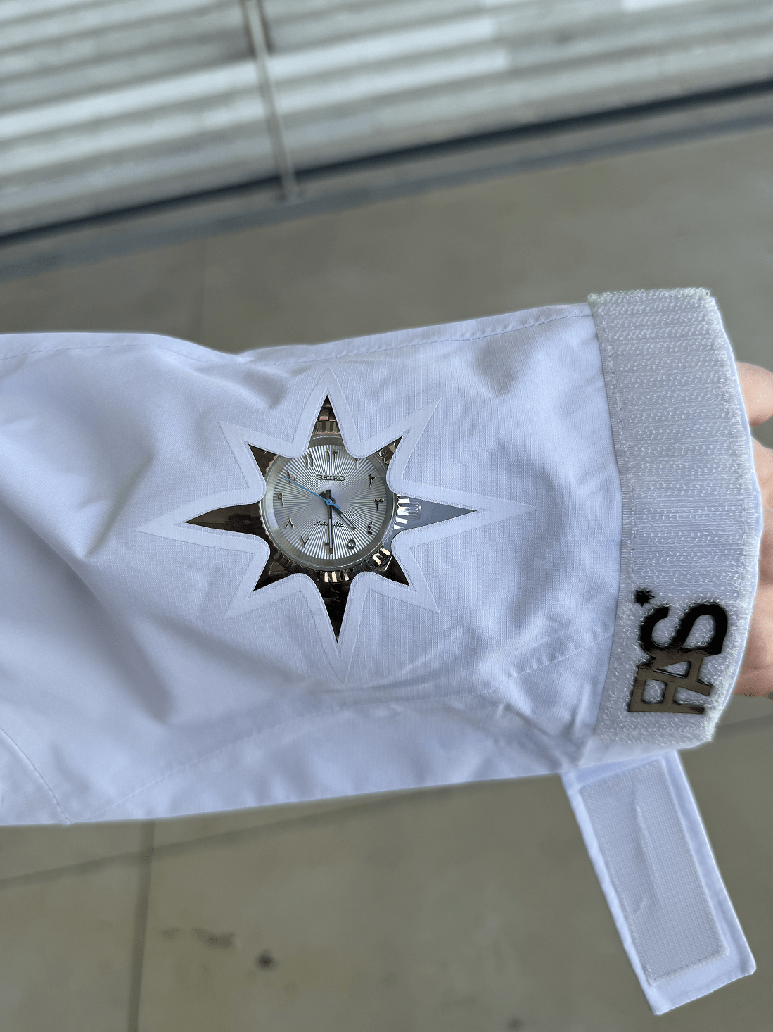 Zoom sur une manche de la Hardshell blanche FAS, détails visibles.