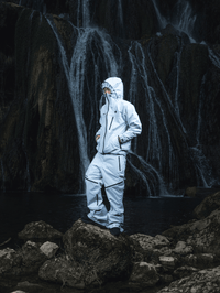 Mannequin sur un rocher en forêt, portant ensemble FAS Hardshell blanc avec casquette.