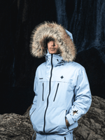 Zoom sur le buste d’un mannequin en forêt portant la Hardshell blanche