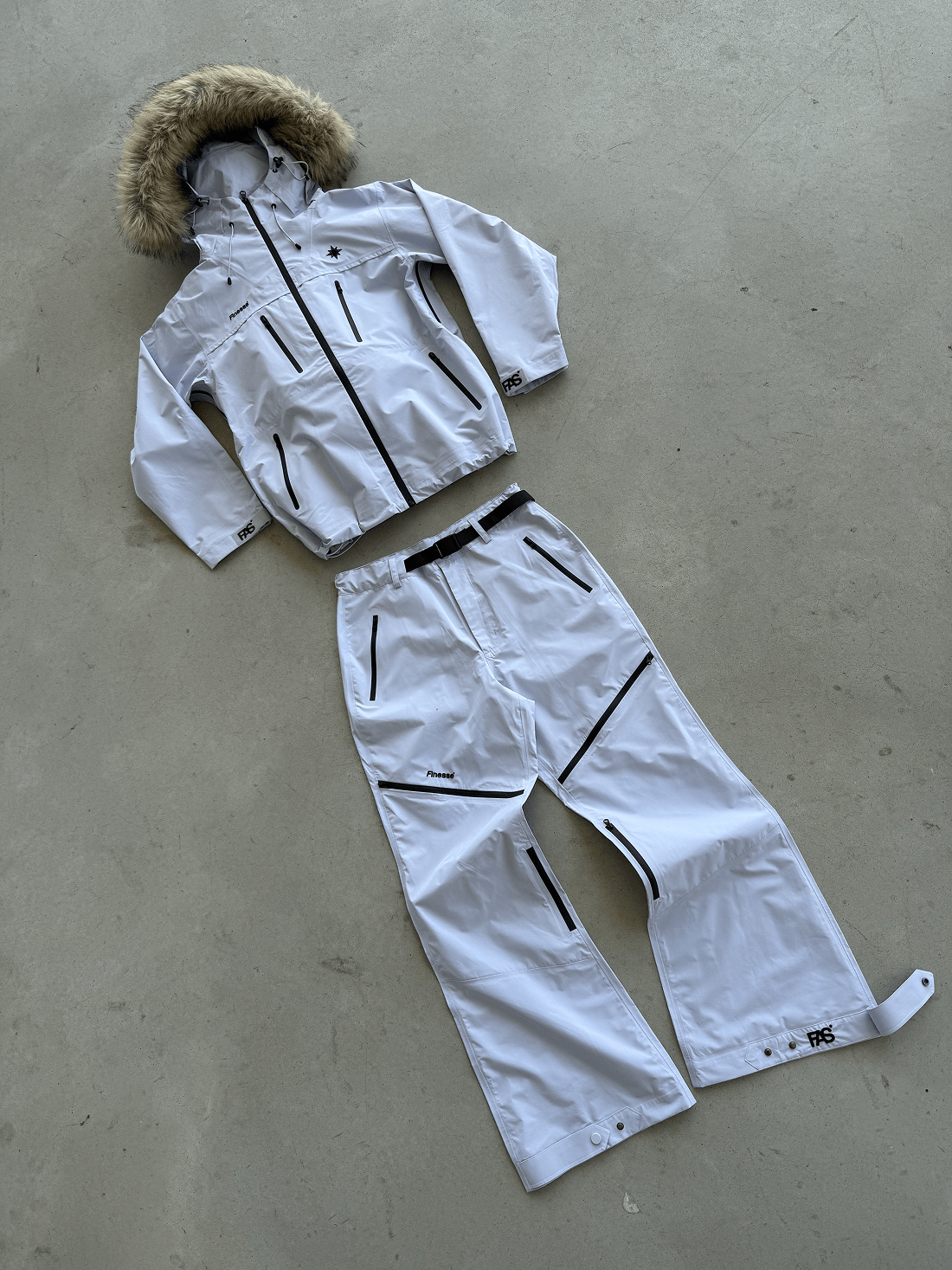 Ensemble complet Hardshell blanche avec fourrure posé au sol.