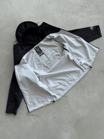 FAS Hardshell noire posée ouverte au sol, capuche et intérieur visibles