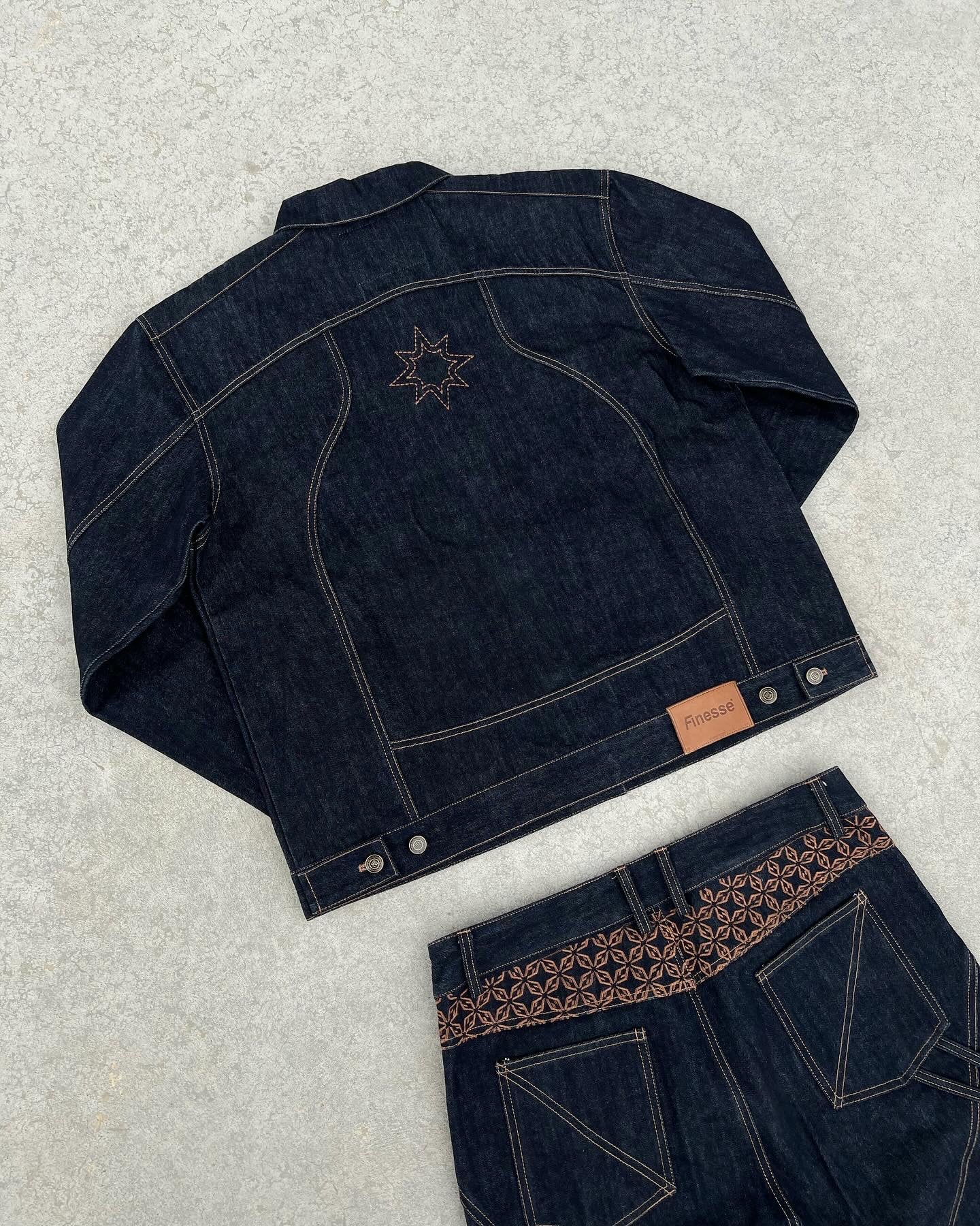 Ensemble FINESSE ADV DENIM SET posé sur sol en béton, focus sur la veste de dos et ses détails.