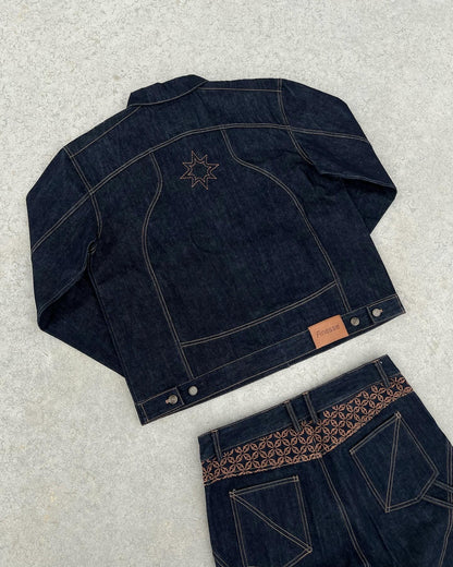 Ensemble FINESSE ADV DENIM SET posé sur sol en béton, focus sur la veste de dos et ses détails.