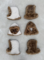 Six capuches FUR HOOD posées au sol, alignées en différentes positions