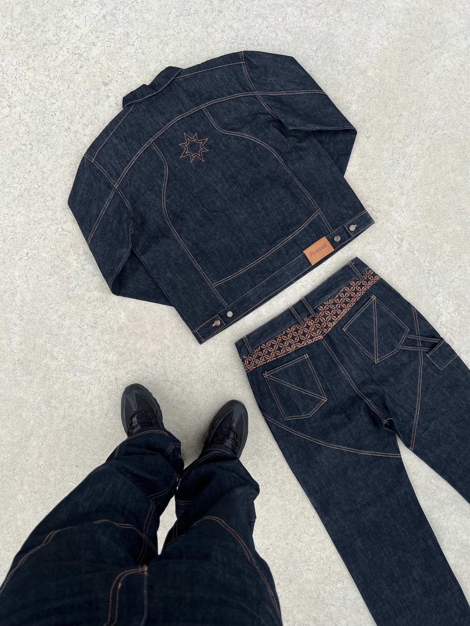 Ensemble Finesse ADV Denim set posé au sol en béton, photographié avec les pieds visibles de l’auteur du cliché