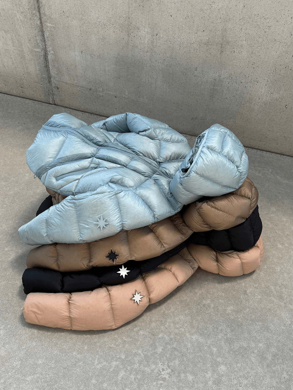 Les quatre doudounes Finesse* Alive Puffer Jacket empilées au sol.