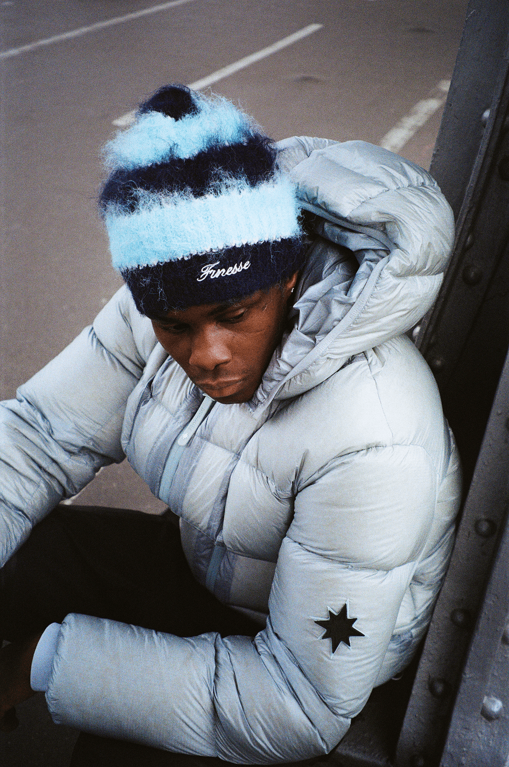 Photo argentique lifestyle d’un homme portant la doudoune Finesse* Alive Puffer Jacket Ice Blue et le Finest Mohair Beanie.