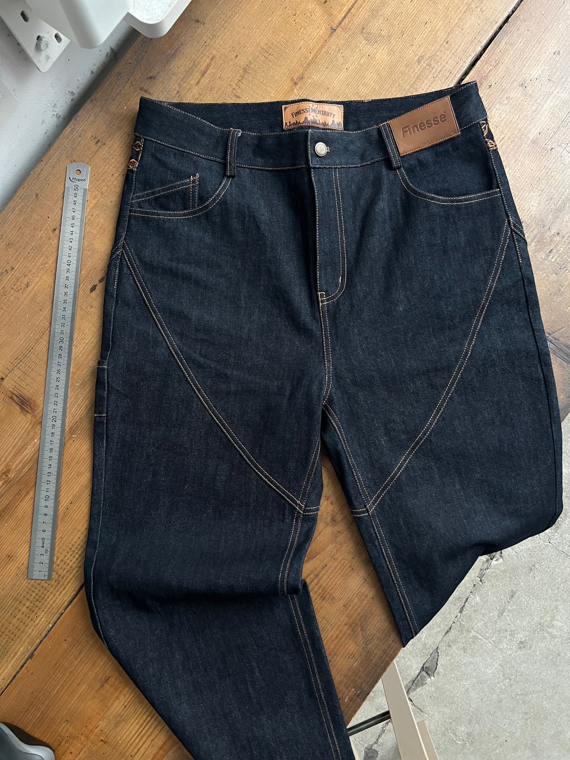 Finesse Denim Jean photographié dans un atelier, posé sur un plan de travail en bois