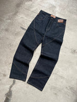 Finesse Denim Jean en packshot, présenté à plat sur sol en béton.