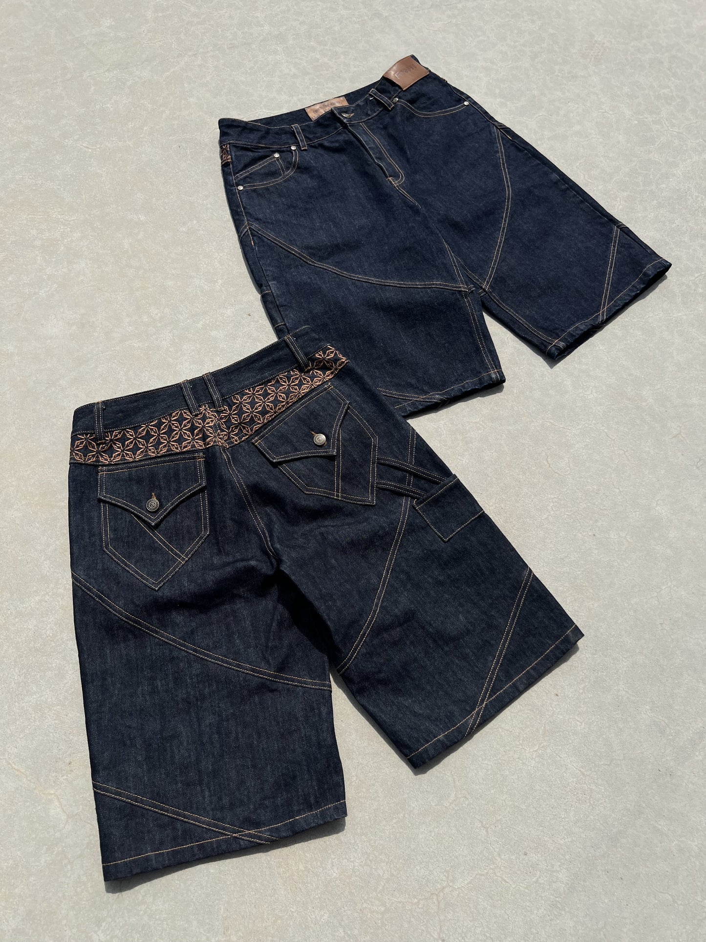Deux Finesse Denim Shorts présentés à plat sur sol en béton, vue avant et arrière.