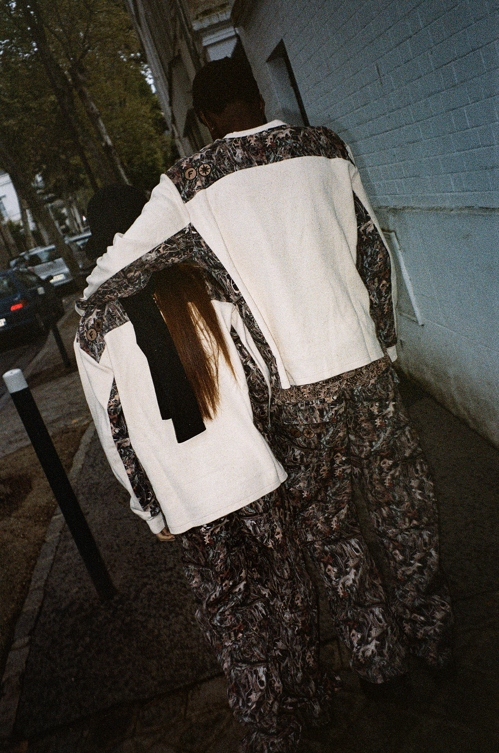 Deux mannequins de dos dans la rue, en Finesse Military Top-Camo et 2-in-1 Cargo Pants-Camo, look streetwear sombre.