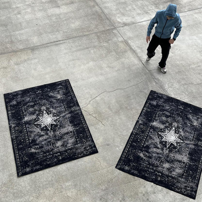 Vue plongeante dans un hangar au sol en béton, avec deux Finesse Rugs et un homme en veste bleue.