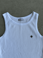 Zoom sur logo pec du Tank Top Finesse blanc posé au sol.