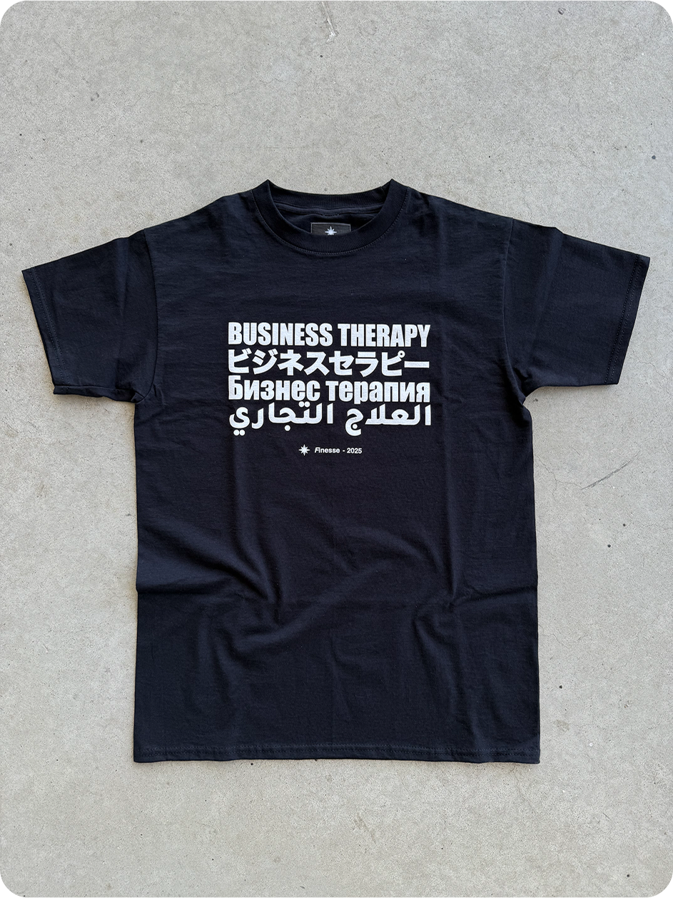 T-shirt Business Therapy Multilingual et deux Trucker Caps posés au sol en packshot.