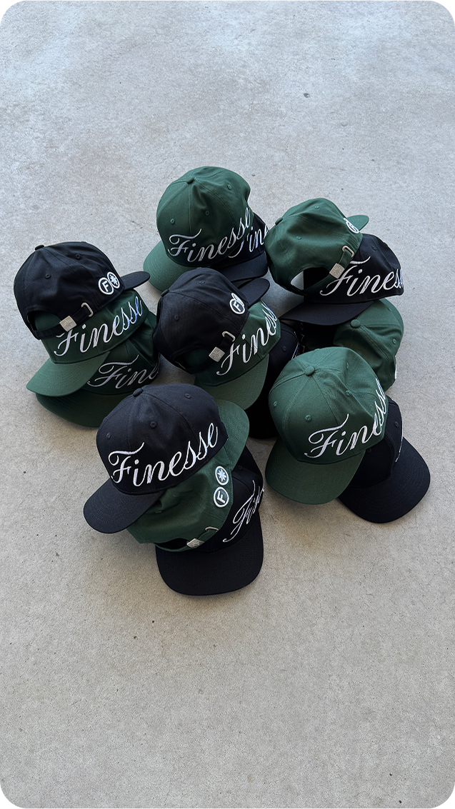 Casquettes Finesse Sign Cap verte et noire posées au sol en packshot.