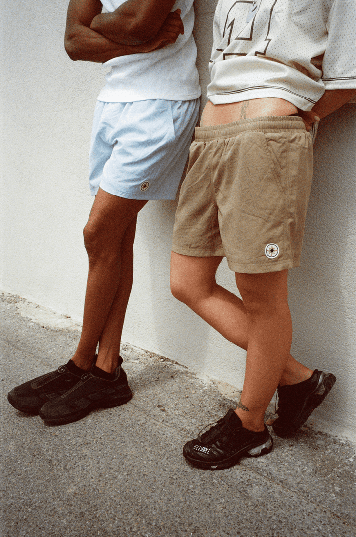 Deux mannequins adossés à un mur, jambes visibles en Swim Shorts.
