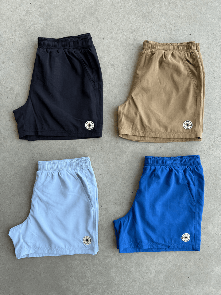 Quatre Finesse Swim Shorts posés ensemble au sol en packshot.