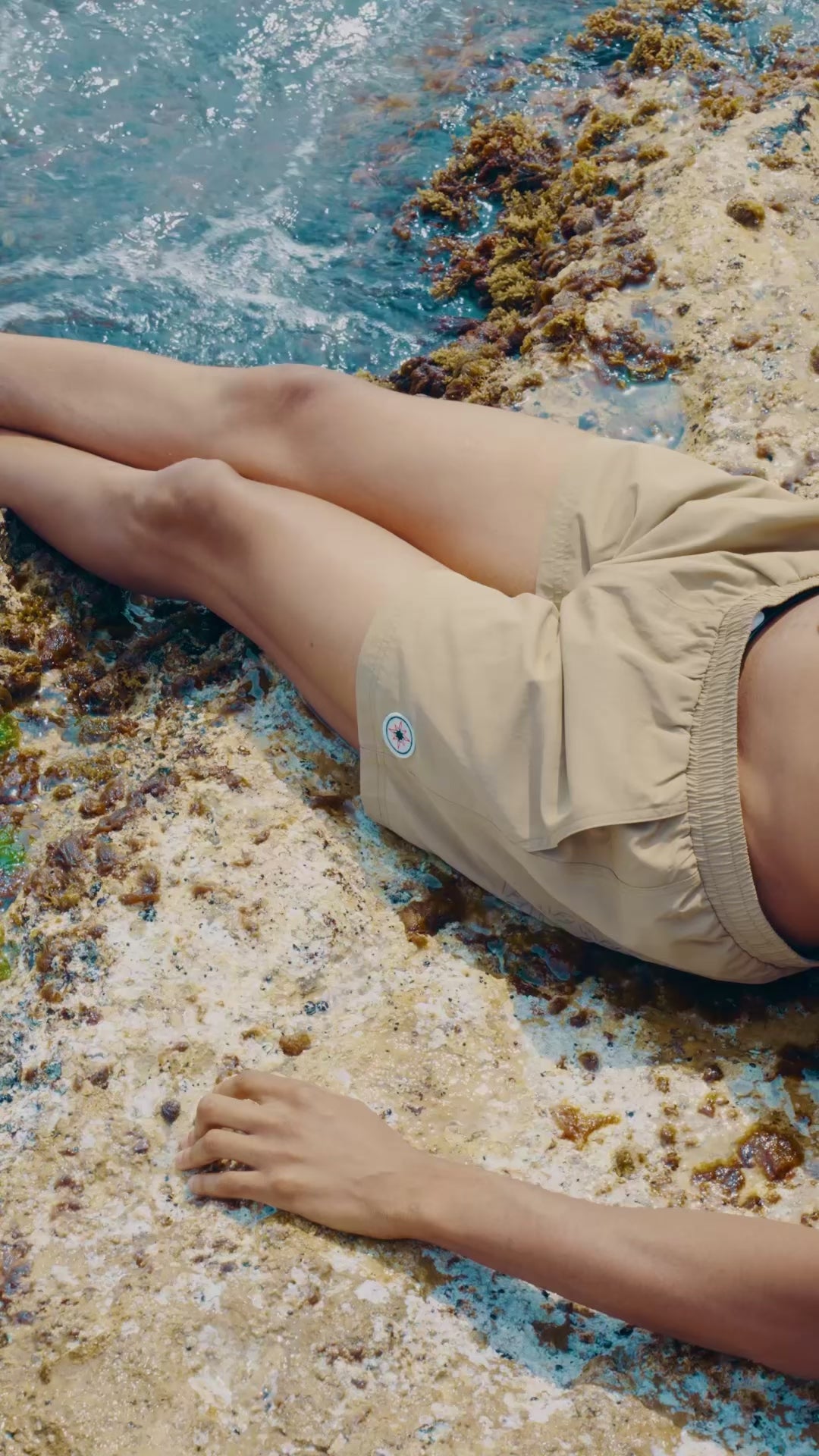 Vidéo d’une femme en Swim Shorts Big Brown, vague révélant le monogramme